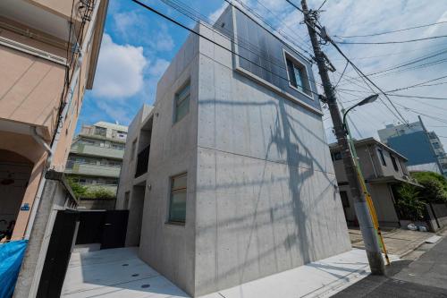 a building with a shadow on the side of it at bmj Hyakunincho in Tokyo