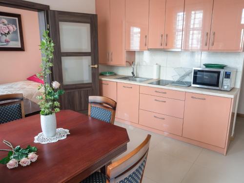 a kitchen with a wooden table with a microwave at Apartamenty na Cichej 5 a3 in Kołobrzeg