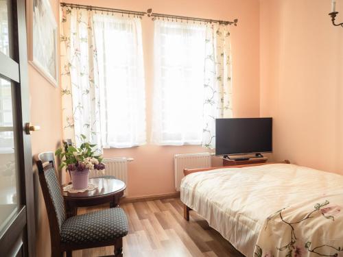 a bedroom with a bed and a table and a tv at Apartamenty na Cichej 5 a3 in Kołobrzeg