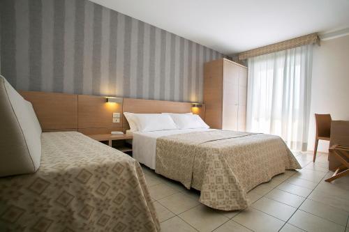 a hotel room with a bed and a window at Hotel Europa Lignano in Lignano Sabbiadoro