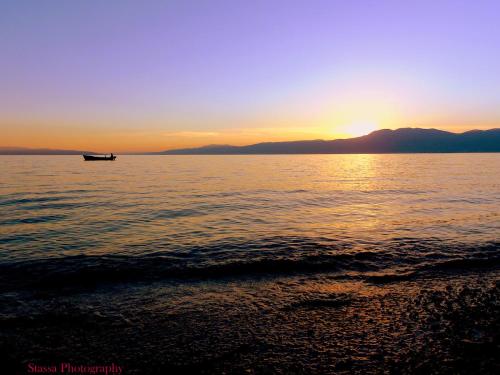 a boat on the water with the sun setting at Volcano Rijeka in Rijeka
