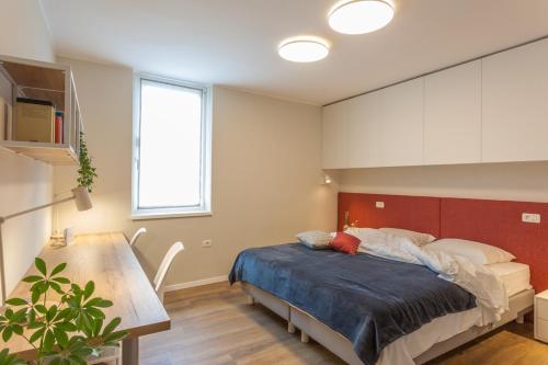 - une chambre avec un lit doté d'une tête de lit rouge dans l'établissement Apartment Evita in the old center of sunny Koper, à Koper