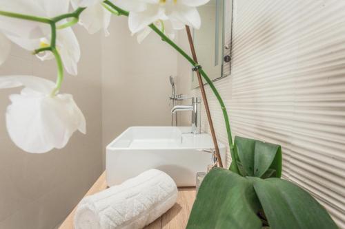La salle de bains est pourvue d'un lavabo et d'une fleur blanche. dans l'établissement Apartment Evita in the old center of sunny Koper, à Koper