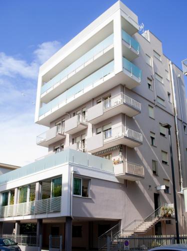 a white building with balconies on the side of it at Hotel Jonni in Sottomarina