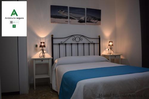 a bedroom with a bed and two tables with lamps at Hostales Juan de Austria I & II in Aguadulce