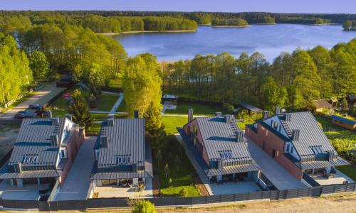an overhead view of a building with a lake in the background at 12 Jabłek - ośrodek wypoczynkowy na Mazurach in Nidzica