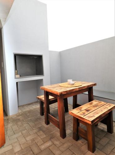 a room with a table and benches and a tv at Tiende Laan Bed & Breakfast and Self-Catering in Walvis Bay