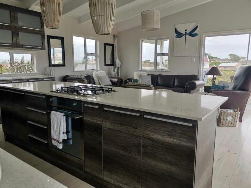 a kitchen with a large island in a living room at The Blue Dragonfly in Jeffreys Bay