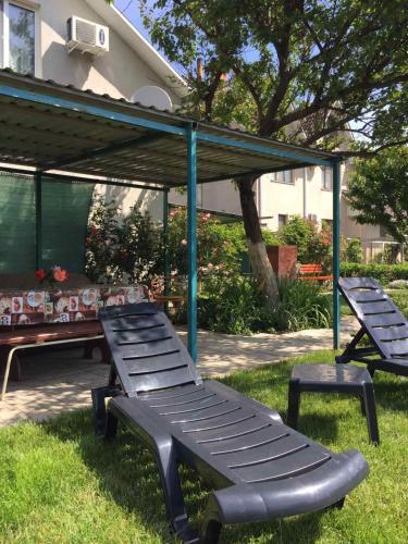 two benches and a picnic table in the grass at Otdykh u moria in Fontanka