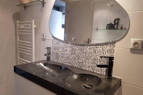un baño con lavabo y espejo en L'Escapadou - Charme et Tranquillité, en Albi