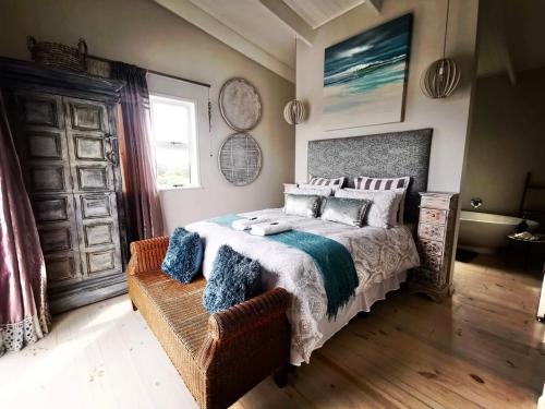 ein Schlafzimmer mit einem großen Bett und einem Fenster in der Unterkunft The Blue Dragonfly in Jeffreys Bay