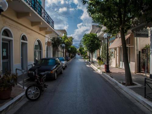 una calle en una ciudad con coches aparcados en Agalide en Kíssamos