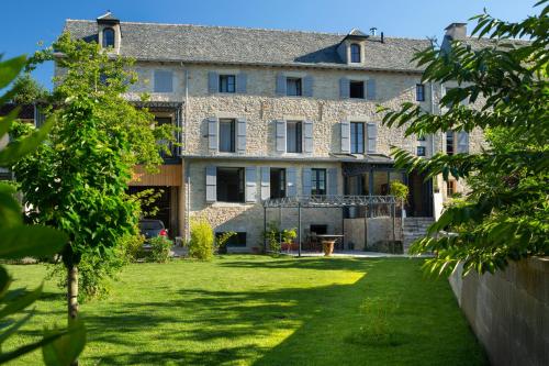 a large stone building with a yard in front of it at La Maison De Siloe in Villefranche-de-Rouergue