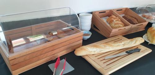 Belle vue D'Olhain في Fresnicourt-le-Dolmen: طاولة عليها صندوق خبز وصينية من أعواد الخبز