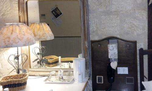 a mirror sitting next to a table with a lamp at Hotel Mignon in Avignon