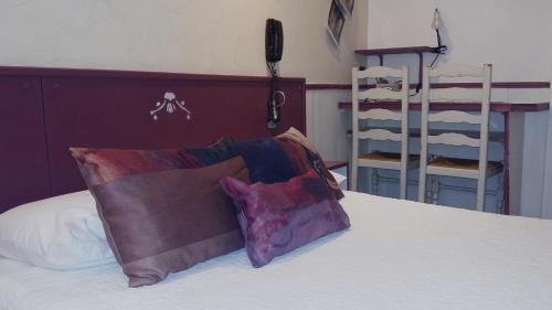 a bed with two pillows sitting on top of it at Hotel Mignon in Avignon