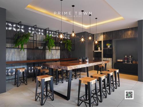a dining room with a large table and stools at PRIME TOWN - Posh & Port Hotel PHUKET in Phuket