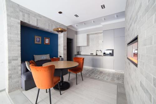 a dining room with a table and orange chairs at Дизайнерські апартаменти на вулиці Краківській 17 в центрі Львова in Lviv