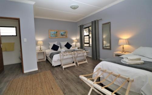 een slaapkamer met 2 bedden en 2 tafels en 2 lampen bij Tiende Laan Bed & Breakfast and Self-Catering in Walvis Bay
