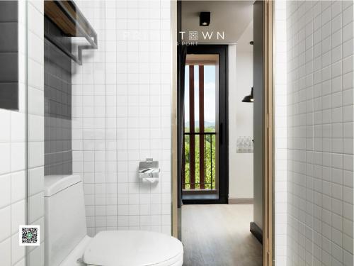 a white bathroom with a toilet and a window at PRIME TOWN - Posh & Port Hotel PHUKET in Phuket Town