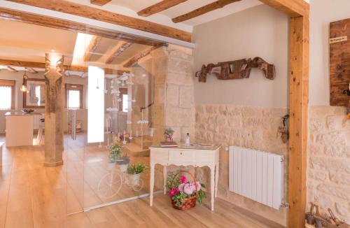 Habitación grande con pared de piedra y mesa blanca. en Praxedes Enea, en Añorbe