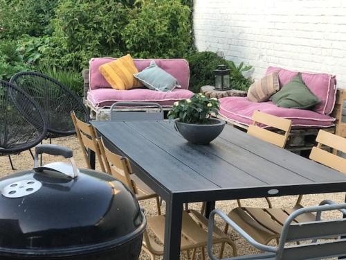 a patio with a grill and a table with a couch at Annex in Oudenaarde