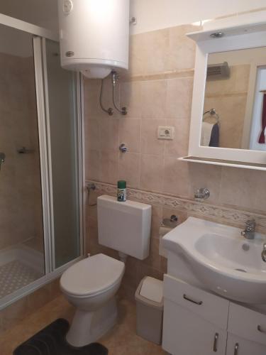 a bathroom with a white toilet and a sink at Villa Miljana in Kraljevica