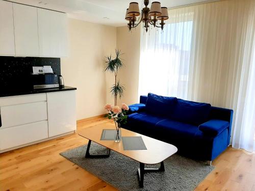 a living room with a blue couch and a coffee table at Bangų gatvė 7 in Klaipėda