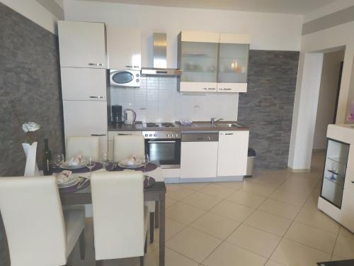 クラリェヴィツァにあるVilla Miljanaの白いキャビネットとテーブル付きのキッチンが備わります。