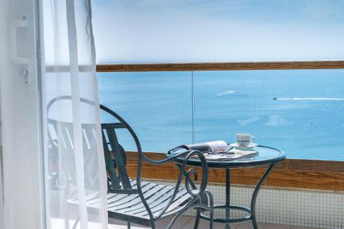 a table and chair on a balcony with the ocean at Royal Beach Eilat by Isrotel Exclusive in Eilat