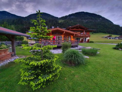 a house in the middle of a yard with a tree at Romantik Pension Lehrberg in Sankt Jakob in Haus