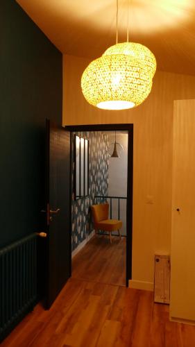 a room with a hallway with a chandelier and a chair at La Rochelle et l'Aunis in Saint-Sauveur-dʼAunis