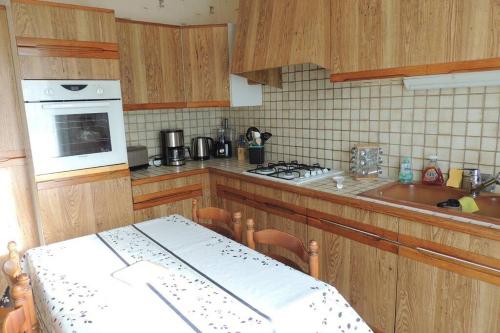 une cuisine avec des armoires en bois et un four à plaques de cuisson dans l'établissement Maison Andinette, à Blis-et-Born