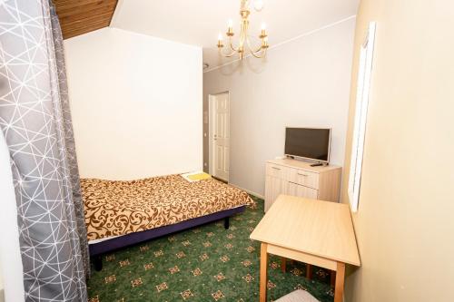 a small room with a bed and a tv at Guest House Rannaliiv in Võsu
