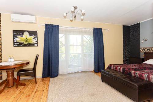 a bedroom with a bed and a table and a window at Guest House Rannaliiv in Võsu