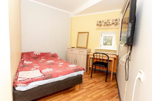 a small bedroom with a bed and a desk at Guest House Rannaliiv in Võsu