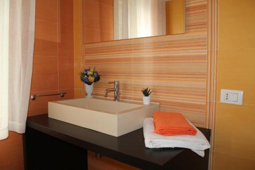 a bathroom sink with an orange towel on a counter at Apartments " Le Ginestre" in Acireale
