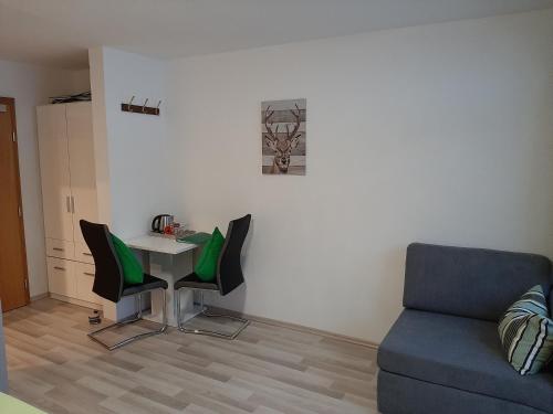 a living room with a table and chairs and a couch at Pension Alpengruss in Heiterwang