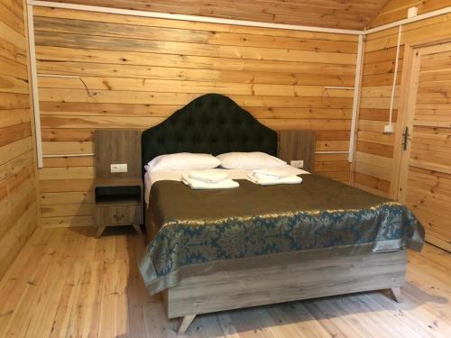 a bedroom with a bed in a room with wooden walls at Yıldız Country Hotel in Sinop