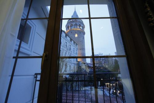 a view of a clock tower through a window at Art Nouveau Galata in Istanbul
