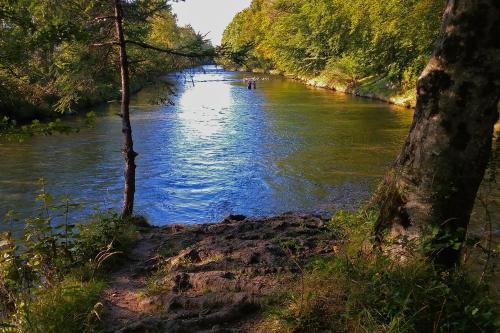 a river with a group of people canoeing on it at Ferienwohnung Gartenglück in Traunstein