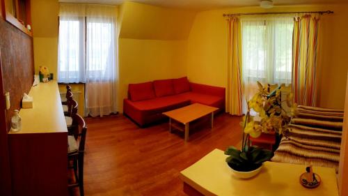 een woonkamer met een rode bank en een tafel bij Apartment 202 in Tatranská Lomnica