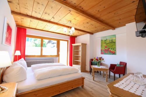 バート・ウィーゼにあるLandhaus Schwabenのベッドルーム1室(大型ベッド1台、テーブル、椅子付)