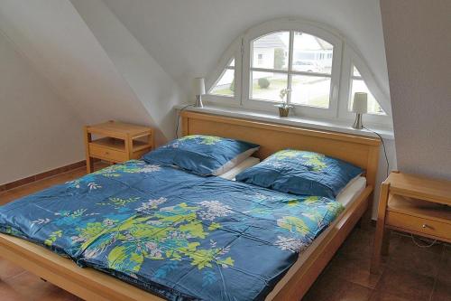 a bedroom with a bed with a window at Ferienhaus das Blaue Haus WS-9a in Born