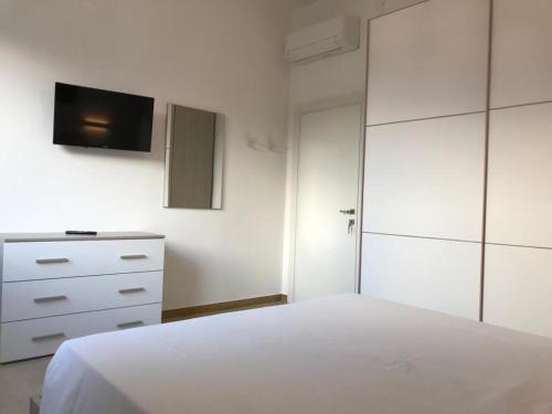 a bedroom with a white bed and a tv on the wall at Eagle Rooms in Riva del Garda