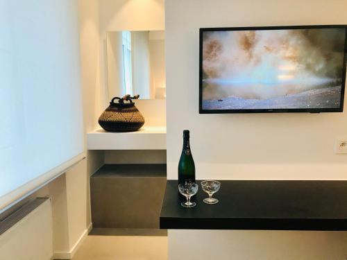 a room with a wine bottle and glasses on a counter at VILLA FER-GUY " Beeldige Suite met parking, nabij strand en casino" in Knokke-Heist