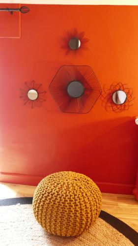 a room with a red wall with eyes and a chair at La Rochelle et l'Aunis in Saint-Sauveur-dʼAunis