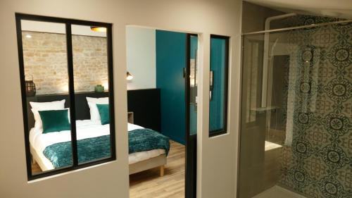 a bedroom with blue walls and a bed and a shower at La Rochelle et l'Aunis in Saint-Sauveur-dʼAunis