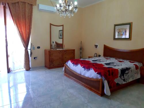 a bedroom with a bed and a mirror and a chandelier at Casa di Roberto in Porto Cesareo
