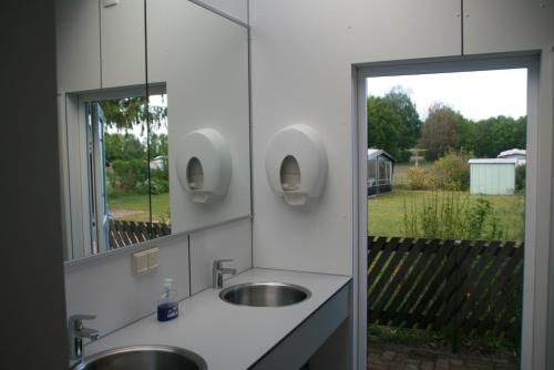 een badkamer met 2 wastafels en een grote spiegel bij Safaritent in Beilen